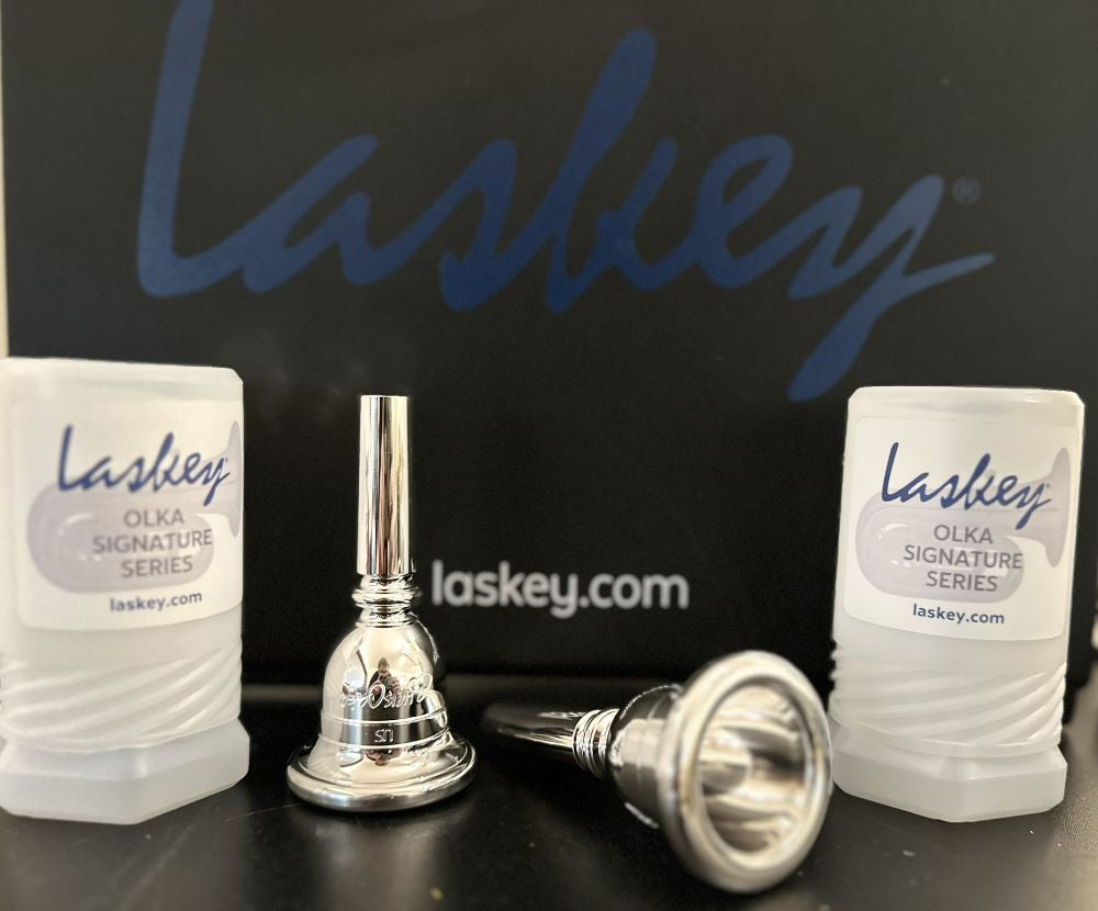 Laskey Olka Signature Series Tuba mouthpieces displayed with protective cases on a black background.